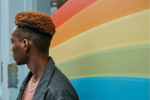 side of persons head with LGBTIQ+ flag colours