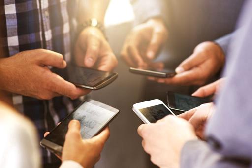 group of peoples hands holding smart phones