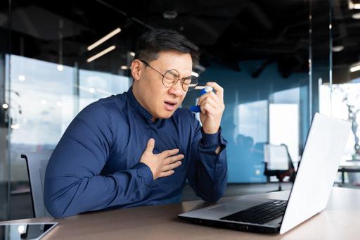 man having panic attack using inhaler