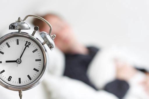 alarm clock with blurred background and someone sleeping