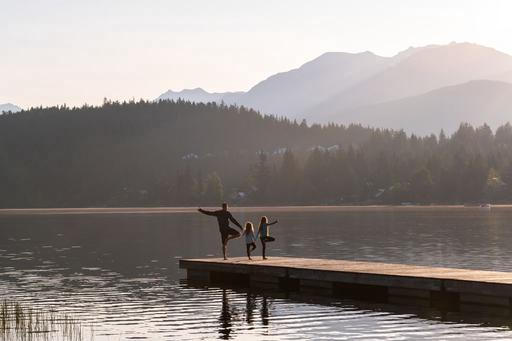 family doing yoga by the river