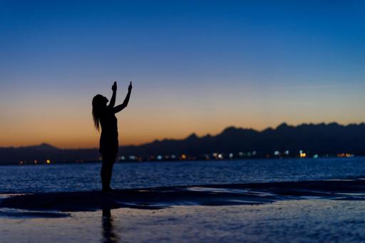 lady on beach at night looking up to night sky